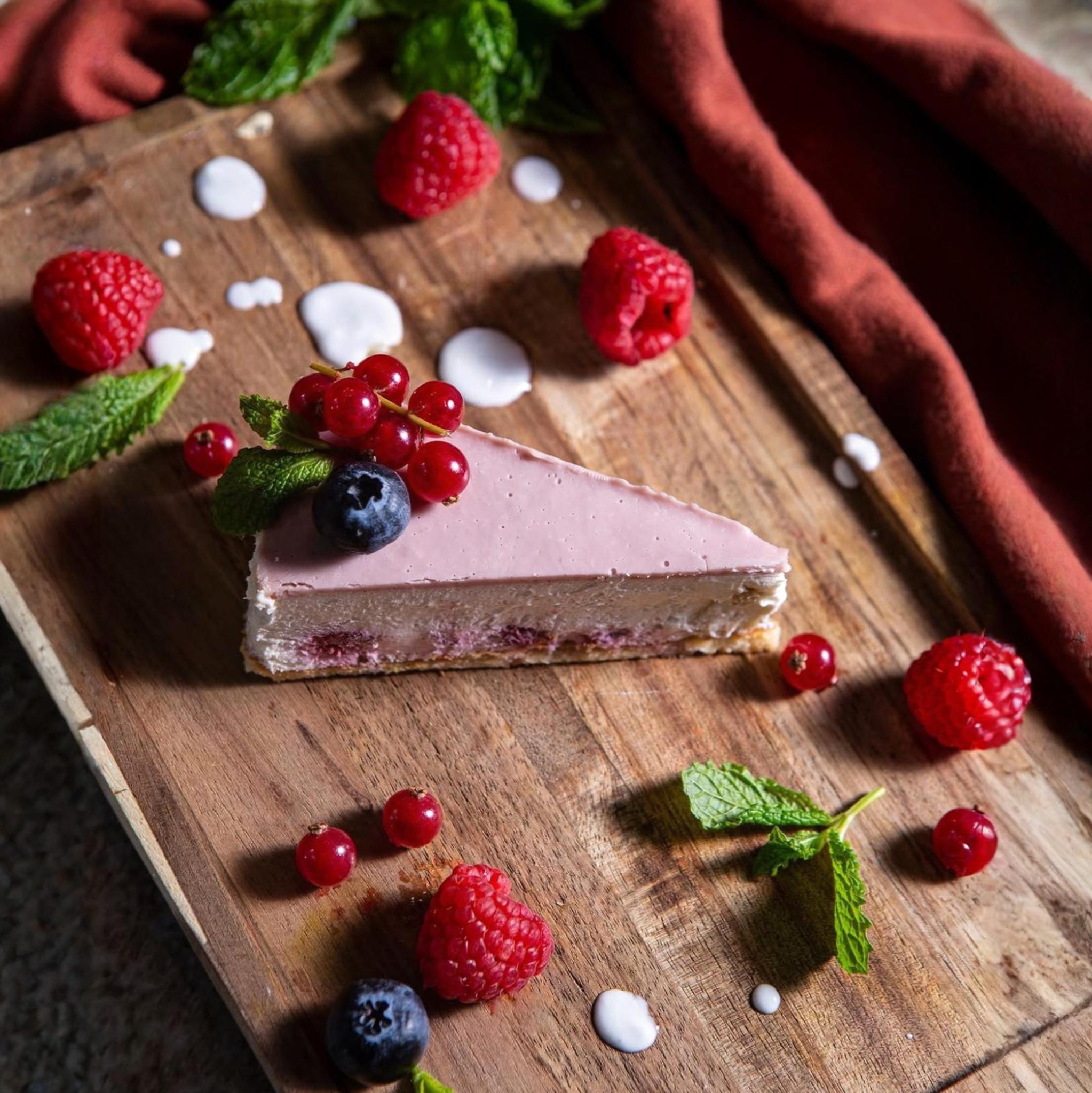 Raspberry cheesecake dessert with fresh berries and vibrant coulis, elegantly plated at Shakinah Indian restaurant in Malta