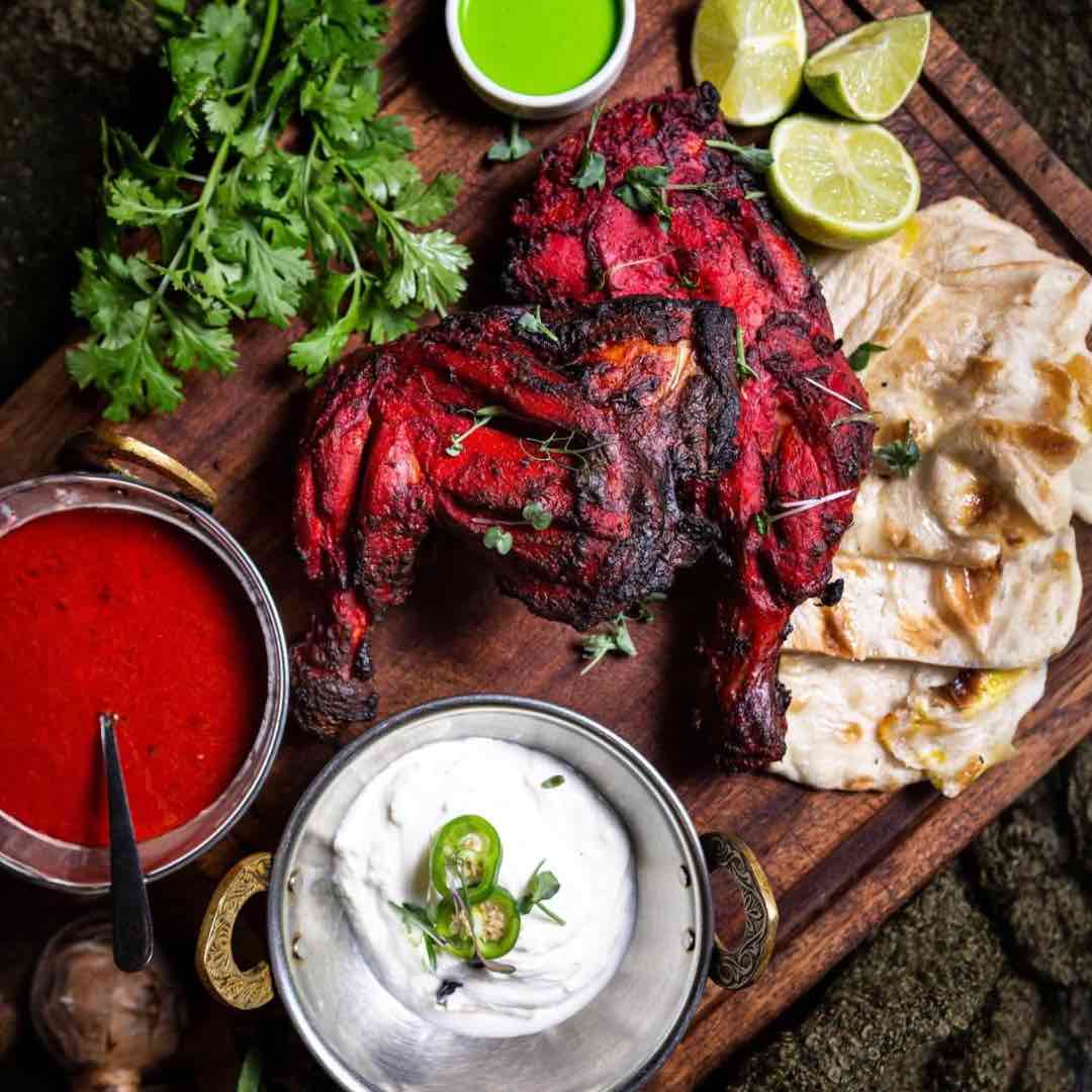 Chicken Tikka sizzling on a grill platter, marinated in Indian spices and served at Shakinah Indian restaurant in Malta